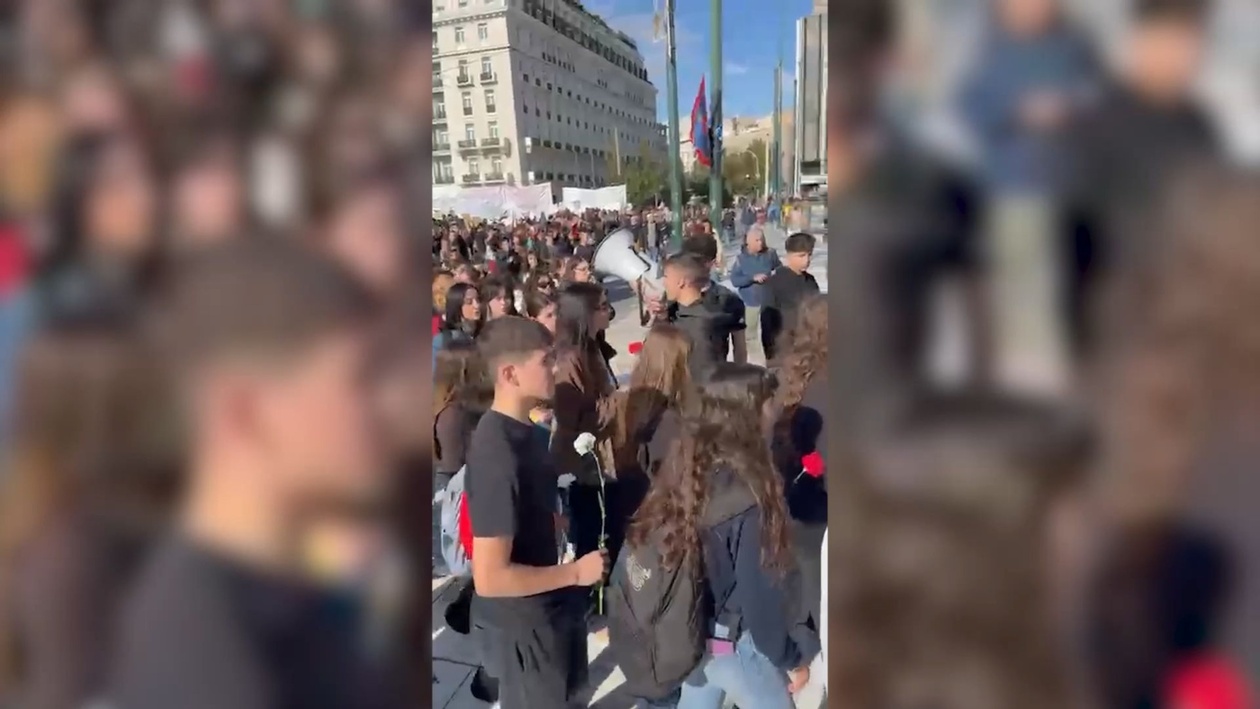 Η στιγμή που μαθητές αφήνουν λουλούδια στο προσωρινό μνημείο των Τεμπών