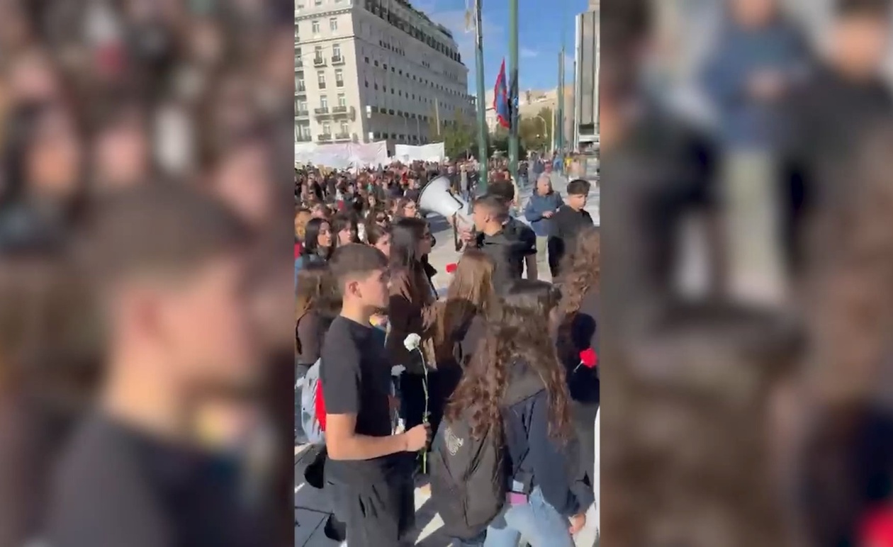 Η στιγμή που μαθητές αφήνουν λουλούδια στο προσωρινό μνημείο των Τεμπών